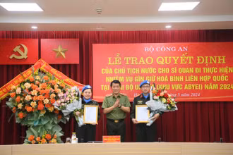 Thượng tướng Lương Tam Quang trao quyết định cho Thiếu tá Vũ Trần Thắng và Đại úy Nguyễn Lan Anh.