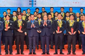 Chủ tịch Quốc hội Trần Thanh Mẫn và Chủ tịch Tổng Liên đoàn Lao động Việt Nam Nguyễn Đình Khang trao biểu trưng biểu dương công nhân lao động tiêu biểu là đảng viên Đảng Cộng sản Việt Nam. (Ảnh: Duy Linh)
