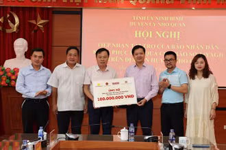 Đại diện Báo Nhân Dân và Công ty cổ phần Văn hóa học và học Việt Nam trao tặng tiền ủng hộ cho huyện Nho Quan (Ninh Bình). 