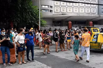 Người dân tại Manila, Philippines, sơ tán ra bên ngoài các tòa nhà sau trận động đất ngày 27/7/2022. (Ảnh minh họa: AFP/ TTXVN)