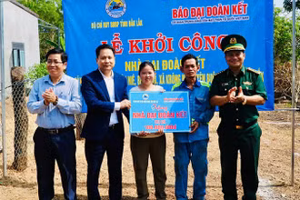 Nhà báo Trương Thành Trung, Tổng Biên tập Báo Đại Đoàn Kết cùng Đại tá Rơ Lan Ngân, Phó Chính ủy, Bộ đội Biên phòng tỉnh Đắk Lắk; lãnh đạo xã Krông Na trao bảng tượng trưng cho gia đình ông Y Hớn Niê. (Ảnh: THANH NGA)