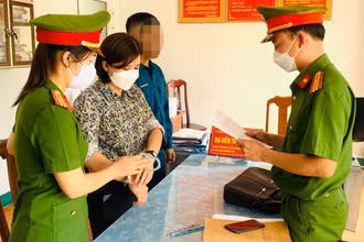 Công an tống đạt quyết định khởi tố bị can, bắt tạm giam Trần Thị Hồng. (Ảnh Công an cung cấp)