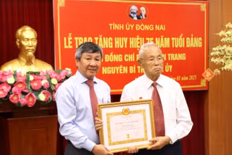 Phó Bí thư Thường trực Tỉnh ủy Đồng Nai Hồ Thanh Sơn trao Huy hiệu 75 năm tuổi đảng cho đồng chí Phan Văn Trang.