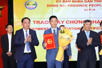 Phó Bí thư Thường trực Tỉnh ủy Hồ Thanh Sơn và Chủ tịch Ủy ban nhân dân tỉnh Đồng Nai Võ Tấn Đức trao giấy chứng nhận đăng ký đầu tư và tặng hoa chúc mừng cho doanh nghiệp.