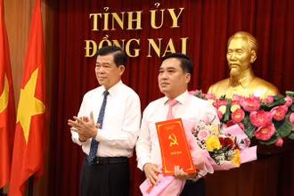 Bí thư Tỉnh ủy Đồng Nai Nguyễn Hồng Lĩnh trao quyết định và tặng hoa chúc mừng đồng chí Hồ Văn Nam.