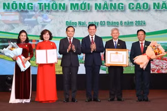Phó Thủ tướng Trần Lưu Quang và Bí thư Tỉnh ủy Đồng Nai Nguyễn Hồng Lĩnh trao danh hiệu huyện nông thôn mới nâng cao, tặng hoa chúc mừng lãnh đạo huyện Xuân Lộc.