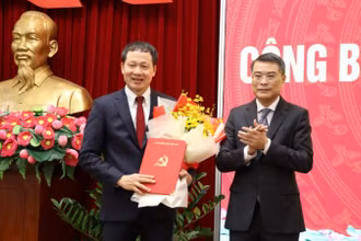 Đồng chí Lê Minh Hưng trao quyết định và tặng hoa chúc mừng đồng chí Vũ Hồng Văn.