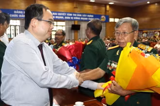 Phó Bí thư Tỉnh ủy, Trưởng Đoàn đại biểu Quốc hội tỉnh Đồng Nai Quản Minh Cường tặng hoa Anh hùng lực lượng vũ trang nhân dân tại buổi họp mặt.