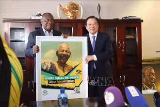 Chủ tịch đảng ANC, Tổng thống Nam Phi Cyril Ramaphosa (trái) tặng quà lưu niệm đồng chí Phan Đình Trạc tại trụ sở đảng. (Ảnh: TTXVN)