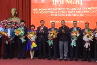 Bộ trưởng Công an Tô Lâm tặng hoa cho đại diện các tổ chức kinh tế, doanh nghiệp đã tài trợ xây nhà ở cho hộ nghèo, hộ nạn nhân chất độc da cam ở tỉnh Hưng Yên.