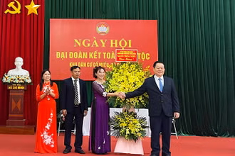 Đồng chí Nguyễn Trọng Nghĩa tặng hoa, chúc mừng Ngày hội Đại đoàn kết toàn dân tộc tại thôn Cổ Miếu.