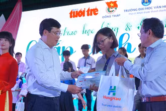 Bí thư Tỉnh ủy Đồng Tháp Lê Quốc Phong và Phó Tổng Biên tập Báo Tuổi Trẻ Nguyễn Hoàng Nguyên trao học bổng, quà cho học sinh. (Ảnh: HỮU NGHĨA)
