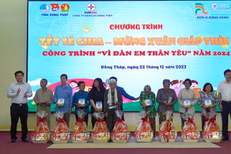 Chủ tịch Ủy ban nhân dân huyện Tháp Mười Đoàn Thanh Bình và Phó Giám đốc Công ty Điện lực Đồng Tháp Nguyễn Chí Thanh trao tặng quà. (Ảnh: HỮU NGHĨA)