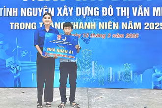 Em Lâm Nguyễn Việt Uyên trao bảng tượng trưng cho em Lý Thiện Đức. (Ảnh: TRUNG THÀNH)
