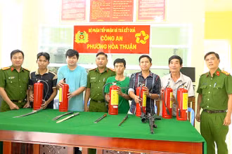 Người dân giao nộp vũ khí tại Công an phường Hòa Thuận và nhận bình chữa cháy. (Ảnh: Công an cung cấp)