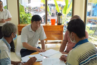 Chủ tịch Ủy ban nhân dân tỉnh Đồng Tháp Phạm Thiện Nghĩa trao đổi với người dân làm thủ tục cấp giấy chứng nhận cơ sở đủ điều kiện an toàn thực phẩm.