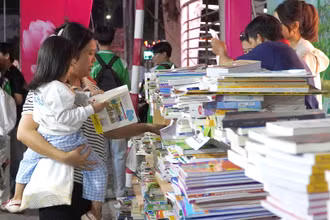 Một cháu bé đi cùng mẹ tại Ngày sách và văn hóa đọc tỉnh Đồng Tháp. (Ảnh: HỮU NGHĨA)