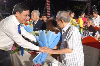 Phó Bí thư Thường trực Tỉnh ủy Đồng Tháp Phan Văn Thắng tặng hoa nhân chứng lịch sử. (Ảnh: HỮU NGHĨA)
