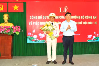 Ủy viên Trung ương Đảng, Bí thư Tỉnh ủy Đồng Tháp Lê Quốc Phong trao Huy hiệu 40 năm tuổi Đảng và tặng hoa chúc mừng Đại tá Nguyễn Văn Hiểu. (Ảnh: Công an cung cấp)