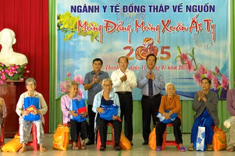 Lãnh đạo ngành Y tế Đồng Tháp và huyện Tháp Mười trao quà cho các hộ gia đình có công với ngành y tế. (Ảnh: HOÀNG KHA)