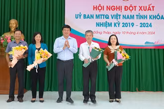Đồng chí Đinh Văn Dũng (thứ 2 từ phải qua) nhận hoa chúc mừng của Bí thư Tỉnh ủy Đồng Tháp Lê Quốc Phong. (Ảnh: HỮU NGHĨA)