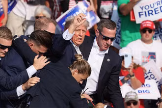 Nhân viên Mật vụ bảo vệ ông Trump rời khỏi sân khấu, nơi ông đang diễn thuyết trong cuộc vận động bầu cử tại bang Pennsylvania, ngày 13/7/2024. (Ảnh: Reuters)