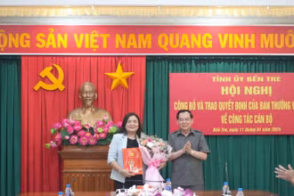Phó Bí thư Tỉnh ủy, Chủ tịch Ủy ban nhân dân tỉnh Bến Tre Trần Ngọc Tam trao Quyết định và hoa chúc mừng đồng chí Hồ Thị Hoàng Yến