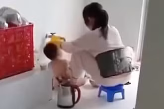 Hình ảnh bảo mẫu đổ thức ăn vào miệng trẻ lan truyền trên mạng xã hội. (Ảnh: Cắt ra từ clip)