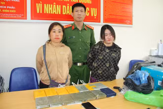 Đối tượng Giàng Thị Chú và Hoàng Cở bị công an bắt giữ cùng tang vật 14 bánh heroin. (Ảnh: QUỲNH TRANG)