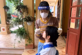 Lấy mẫu xét nghiệm cúm A trên học sinh ở thị trấn Phố Ràng, huyện Bảo Yên, tỉnh Lào Cai. (Ảnh TL)