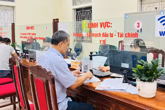 Cán bộ bộ phận một cửa huyện Ba Vì hỗ trợ người dân đến làm thủ tục hành chính. 