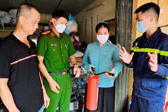 Cán bộ Cảnh sát PCCC và CNCH Công an huyện Thanh Trì, TP Hà Nội hướng dẫn tiểu thương chợ Yên Mỹ, huyện Thanh Trì sử dụng bình chữa cháy. (Ảnh HUY HOÀNG) 
