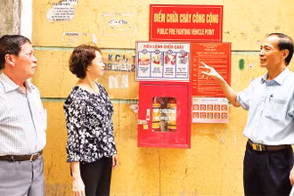 Ông Trương Ðình Quý (bên phải), Bí thư Chi bộ kiêm Trưởng ban Công tác Mặt trận Tổ dân phố số 5, phường Trung Văn hướng dẫn người dân sử dụng phương tiện chữa cháy. 