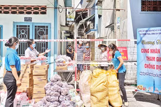 Cán bộ Mặt trận và các tổ chức thành viên trao thực phẩm hỗ trợ người dân trong giai đoạn đại dịch Covid-19 diễn biến căng thẳng tại Thành phố Hồ Chí Minh. 