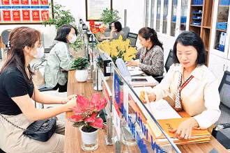 Người dân thực hiện giải quyết thủ tục hành chính tại Bộ phận một cửa quận Ðống Ða. (Ảnh Nguyên Bảo) 
