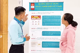 Nhân viên y tế tại Bệnh viện Nhân Dân 115 hướng dẫn người dân sử dụng hồ sơ sức khỏe điện tử trên VNeID. (Ảnh CTV) 