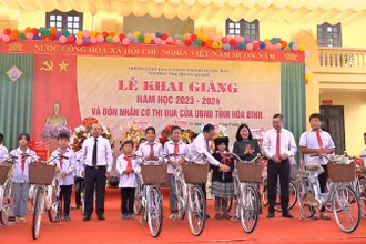 Đồng chí Bùi Thị Minh Hoài cùng lãnh đạo tỉnh Hòa Bình tặng xe đạp cho học sinh tại buổi Lễ khai giảng năm học mới.