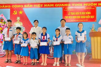 Các đồng chí Đỗ Ái Lam, Phó Chủ tịch Ủy ban nhân dân thành phố Bạc Liêu (nữ) và Trưởng phòng Giáo dục và Đào tạo thành phố Bạc Liêu Trần Bằng Phi trao quà, học bổng các em học sinh khó khăn, hiếu học.