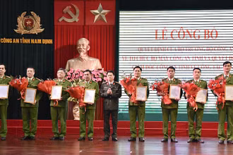 Đại tá Nguyễn Hữu Mạnh, Giám đốc Công an tỉnh Nam Định trao quyết định, tặng hoa chúc mừng các đồng chí nhận công tác mới. 