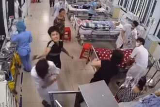 Thanh niên áo đen dùng tay đánh điều dưỡng viên Nguyễn Văn H. (Ảnh cắt từ video clip)