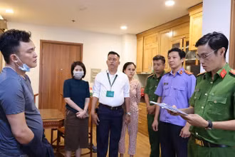 Lực lượng chức năng đọc lệnh khám xét và bắt tạm giam bị can.