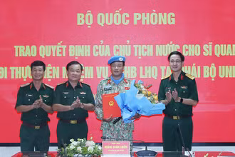 Thượng tướng Hoàng Xuân Chiến trao Quyết định của Chủ tịch nước và tặng hoa chúc mừng Trung tá Đặng Quốc Tuấn. 