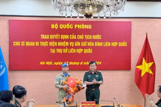 Thượng tướng Hoàng Xuân Chiến trao Quyết định của Chủ tịch nước và tặng hoa chúc mừng Thượng tá Trương Anh Tuấn đi thực hiện nhiệm vụ tại Trụ sở Liên hợp quốc.