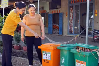 Cán bộ Hội Liên hiệp Phụ nữ xã Lang Minh, huyện Xuân Lộc, tỉnh Đồng Nai hướng dẫn người dân phân loại rác tại nguồn. (Ảnh MẠNH THÌN)