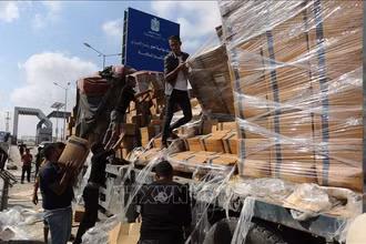 Người dân chuyển hàng cứu trợ nhân đạo tại cửa khẩu Rafah ở Dải Gaza. (Ảnh: THX/TTXVN)