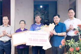 Bí thư Tỉnh ủy Bắc Giang Dương Văn Thái (thứ 2, phải sang) tặng quà cho đại diện gia đình vận động viên Nguyễn Thị Oanh.