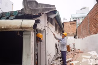 Các công nhân tháo dỡ hạng mục vi phạm xây dựng tại Nhà cổ dân dụng Vương Hồng Sến. (Ảnh: THẾ ANH)