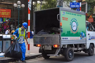 Công nhân Công ty Môi trường đô thị Hà Nội thu gom rác thải trên địa bàn quận Hoàn Kiếm. (Ảnh PHẠM HÙNG)
