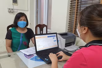 Hỗ trợ phụ huynh đăng ký tuyển sinh trực tiếp tại Trường tiểu học Nghĩa Tân, quận Cầu Giấy, Hà Nội. (Ảnh Thùy Dung)
