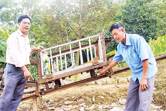 Một phần hệ thống máy vận chuyển trên địa hình dốc của ông Trần Văn Túy (bên phải).
